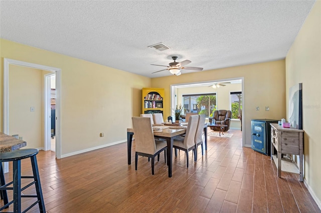 dining space with hardwood / wood-style floors, a textured ceiling, and ceiling fan