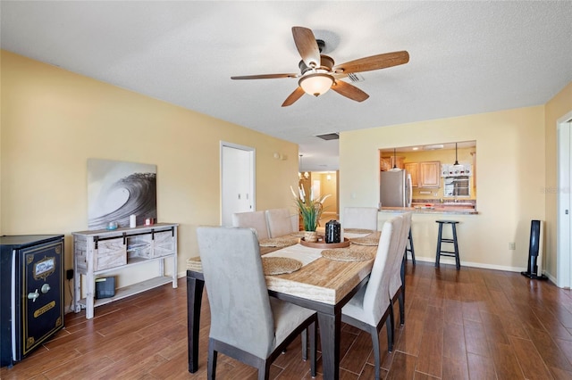 dining space with a textured ceiling, dark hardwood / wood-style floors, and ceiling fan