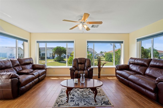 living room featuring dark hardwood / wood-style floors, a wealth of natural light, and ceiling fan