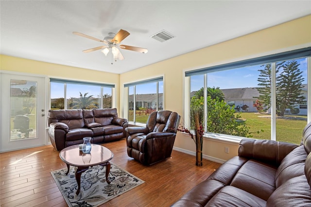 living room with wood-type flooring, a wealth of natural light, and ceiling fan