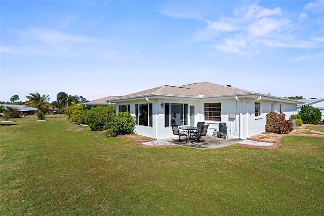 back of property with a lawn and a patio area