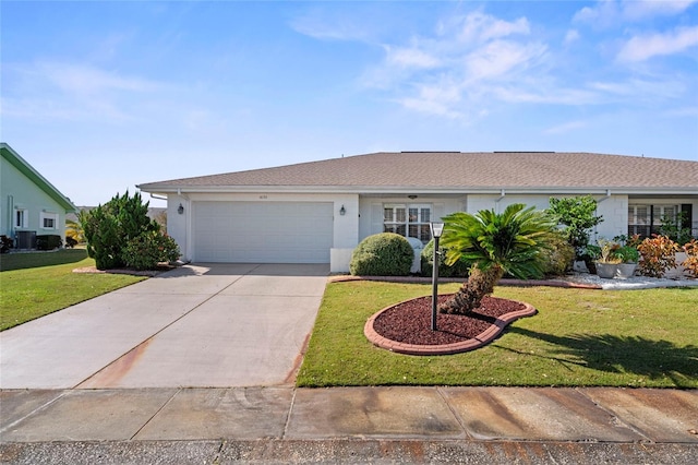 ranch-style home featuring central air condition unit, a front yard, and a garage