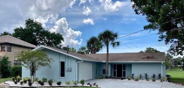 view of front of property featuring driveway, an attached garage, and stucco siding