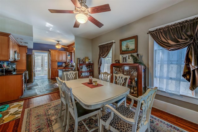 dining area with ceiling fan and dark hardwood / wood-style flooring