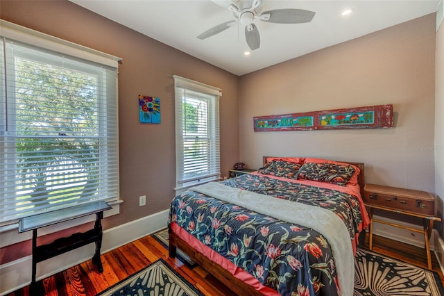 bedroom with hardwood / wood-style flooring, multiple windows, and ceiling fan