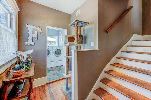 interior space with lofted ceiling, washer and clothes dryer, and wood-type flooring