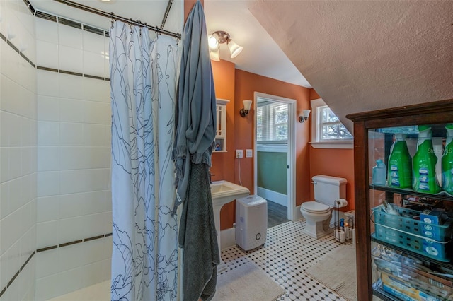 bathroom with curtained shower, a textured ceiling, and toilet