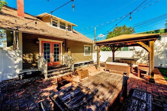 wooden deck featuring a gazebo, an outdoor living space, french doors, and a patio area