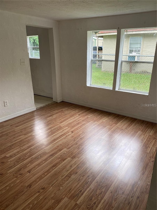 spare room featuring hardwood / wood-style floors and a textured ceiling