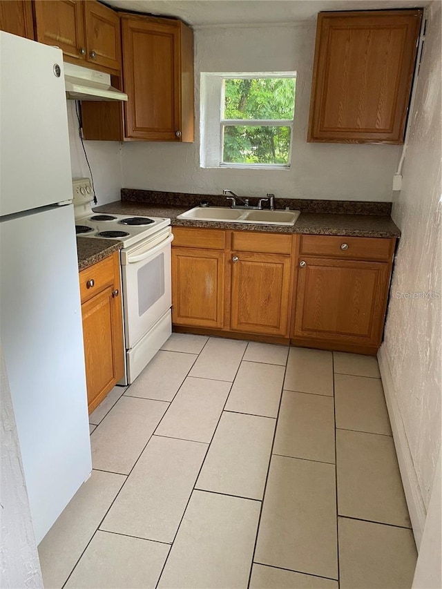 kitchen with white appliances, sink, and light tile patterned floors