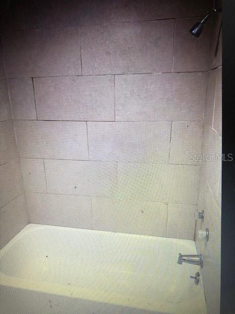 bathroom with tiled shower / bath combo