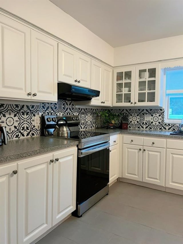 kitchen with decorative backsplash, white cabinets, and stainless steel range with electric cooktop