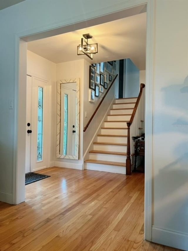 foyer entrance featuring a notable chandelier and light wood-type flooring