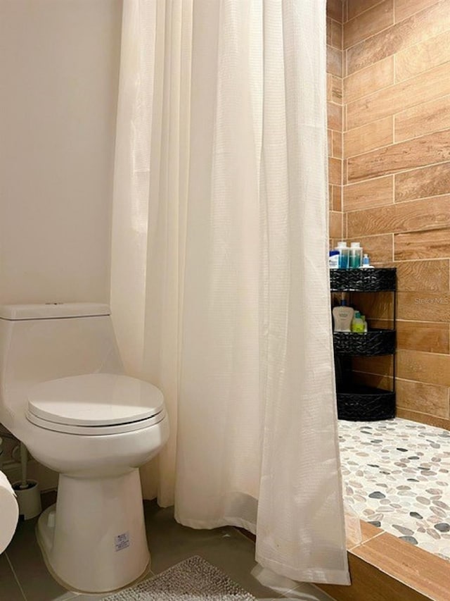 bathroom with a shower with curtain and toilet