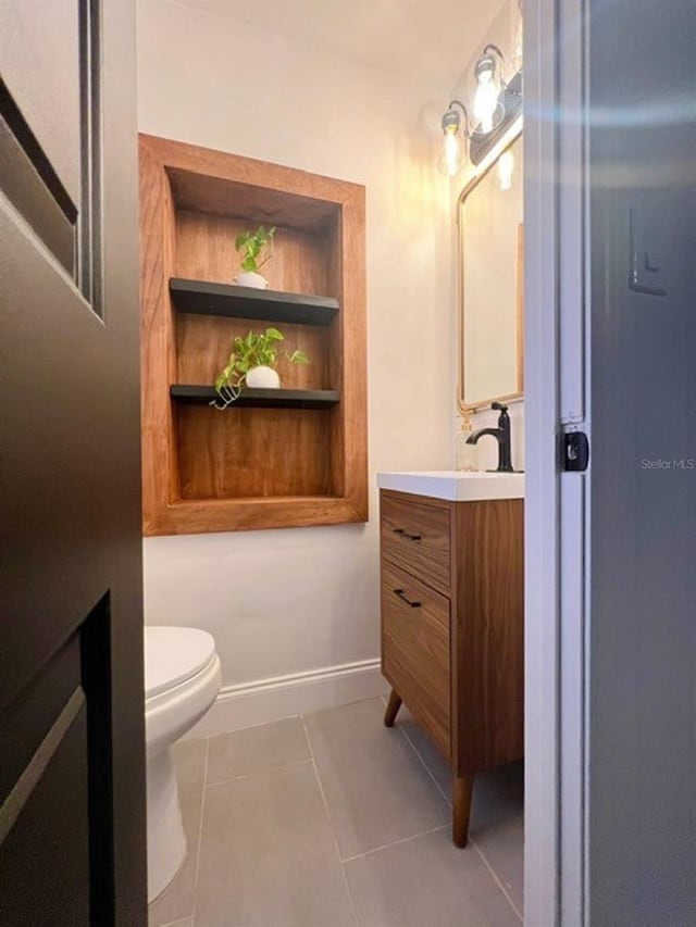 bathroom featuring toilet, vanity, and tile patterned floors