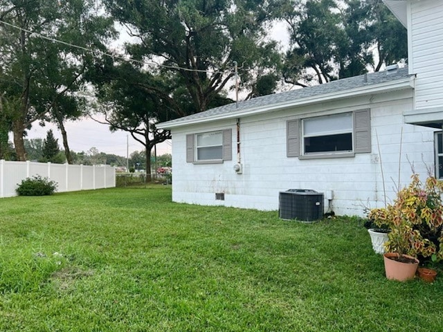 view of property exterior with central AC and a lawn