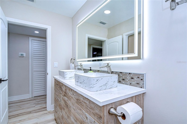 1802 E Hamilton Ave, Tampa, FL 33610 - bathroom with wood finished floors, backsplash, vanity, and recessed lighting