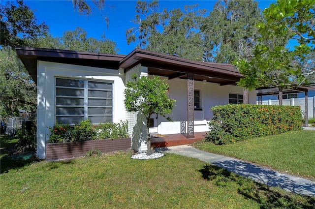 1802 E Hamilton Ave, Tampa, FL 33610 - view of front facade with a front lawn, stucco siding, and covered porch
