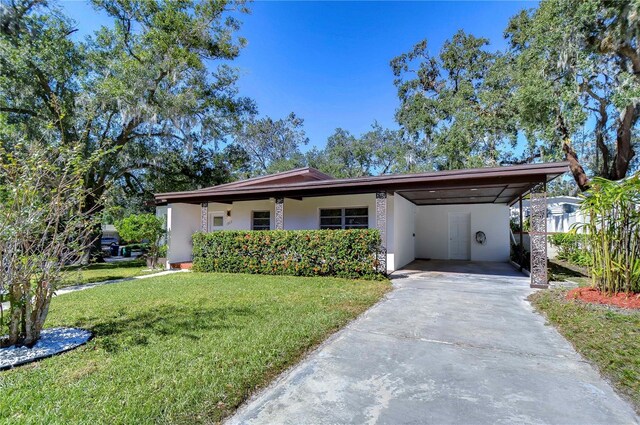 1802 E Hamilton Ave, Tampa, FL 33610 - view of front of home with a front lawn, stucco siding, concrete driveway, and a carport
