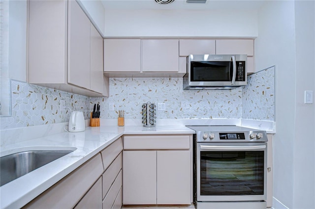 1802 E Hamilton Ave, Tampa, FL 33610 - kitchen with stainless steel appliances, backsplash, and light stone counters