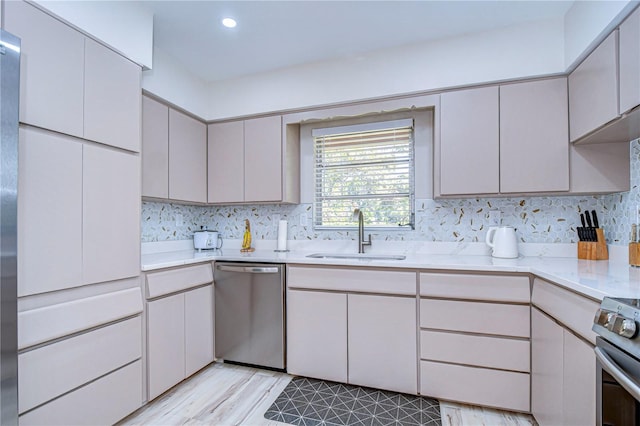 1802 E Hamilton Ave, Tampa, FL 33610 - kitchen with stainless steel appliances, light countertops, backsplash, light wood-style floors, and recessed lighting