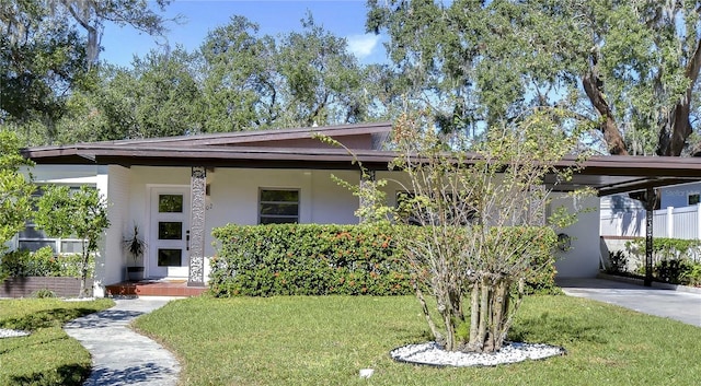 1802 E Hamilton Ave, Tampa, FL 33610 - mid-century modern home with stucco siding, a front yard, and an attached carport
