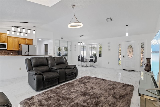 living room with sink, vaulted ceiling, and a textured ceiling