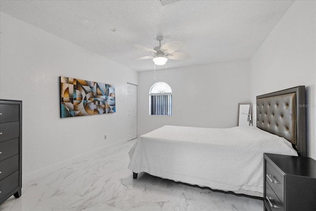 bedroom with a textured ceiling and ceiling fan