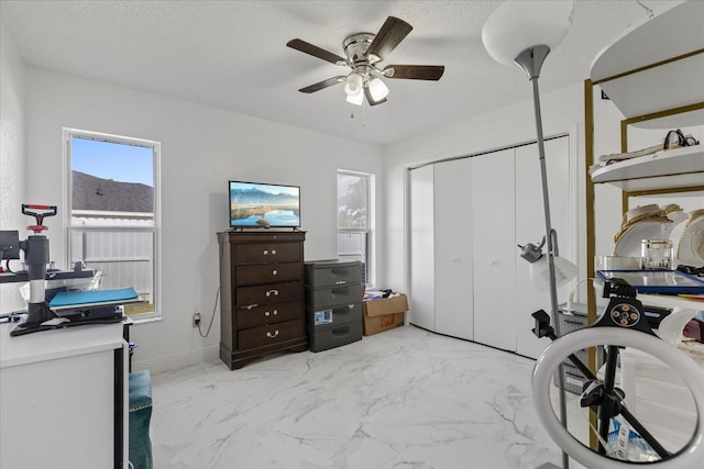 home office featuring ceiling fan and a textured ceiling