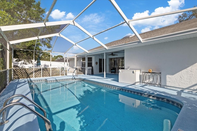 view of pool featuring a patio area, glass enclosure, and ceiling fan