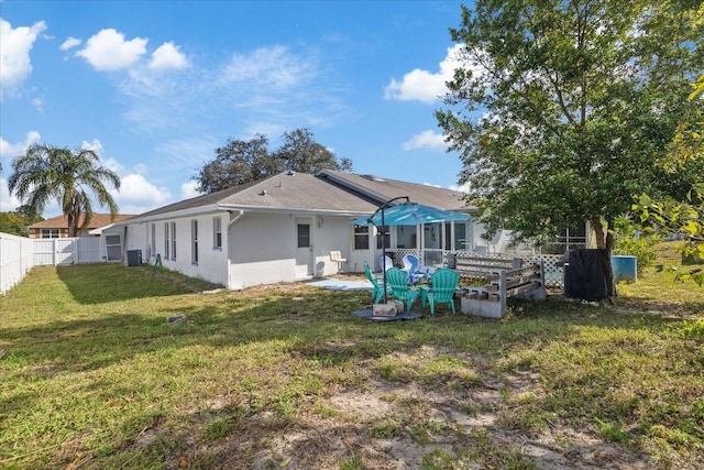 rear view of property featuring a yard, cooling unit, and a patio area