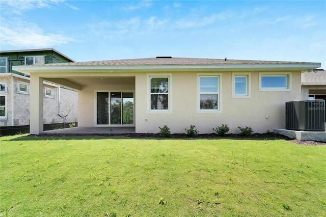 rear view of property featuring a yard and central air condition unit