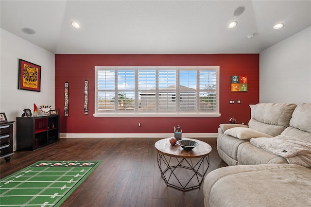 living room featuring dark wood-type flooring and a healthy amount of sunlight