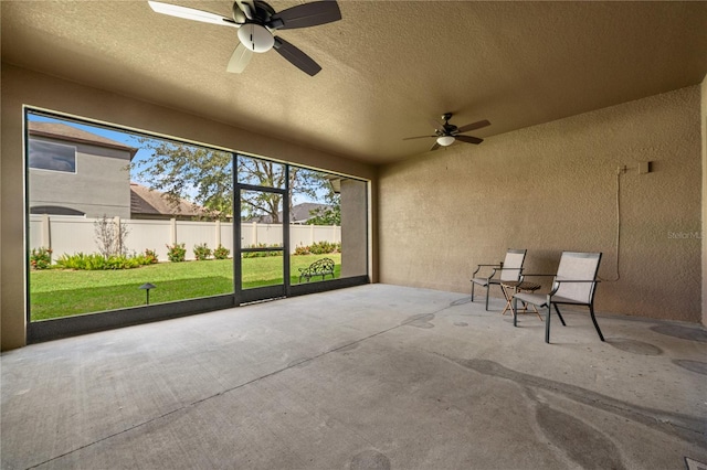 unfurnished sunroom featuring ceiling fan