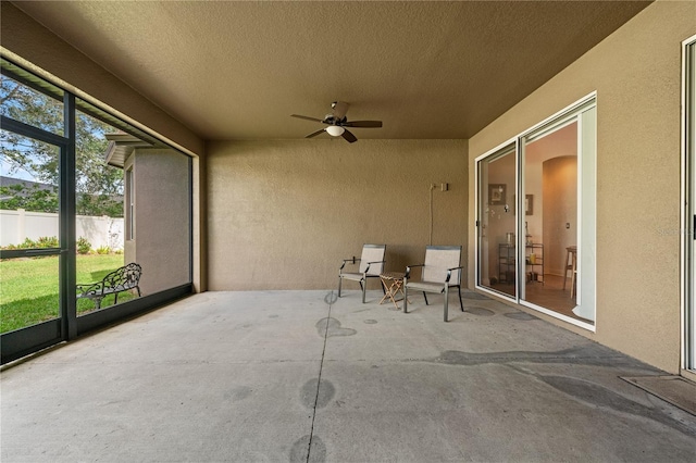 unfurnished sunroom featuring ceiling fan