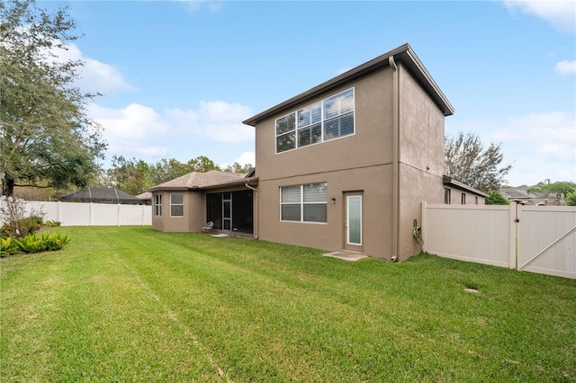 rear view of house featuring a lawn