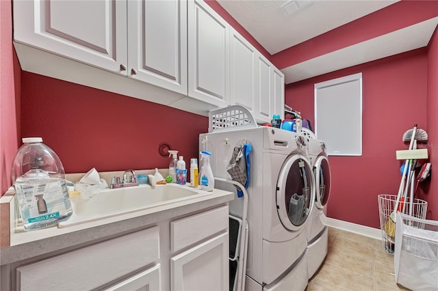 clothes washing area with cabinets, sink, and separate washer and dryer