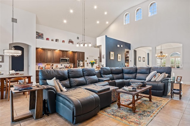 tiled living room featuring an inviting chandelier and high vaulted ceiling