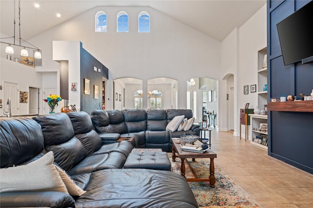 living room with light tile patterned flooring, a chandelier, and high vaulted ceiling