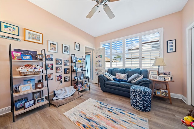 sitting room with hardwood / wood-style floors and ceiling fan