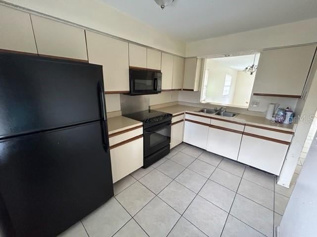 kitchen featuring sink, black appliances, and light tile patterned floors