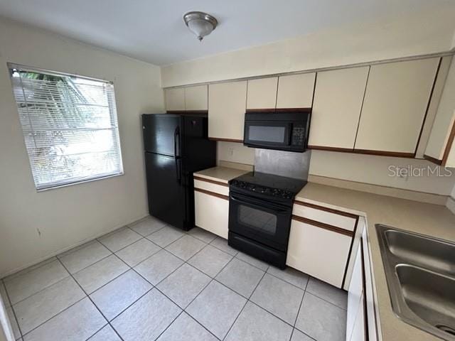 354 Camillia Ln Unit B, Port Charlotte, FL 33954 - kitchen featuring black appliances, light countertops, light tile patterned floors, and a sink