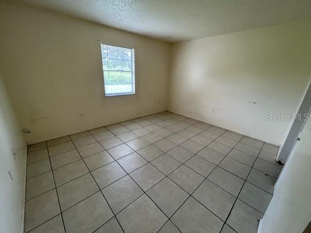 354 Camillia Ln Unit B, Port Charlotte, FL 33954 - empty room with light tile patterned floors and a textured ceiling
