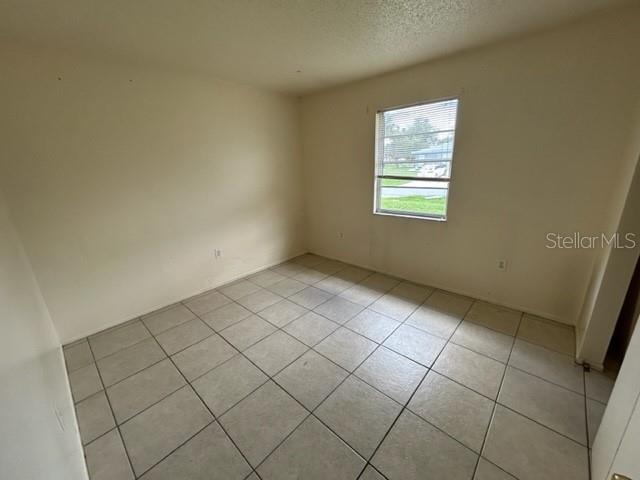 354 Camillia Ln Unit B, Port Charlotte, FL 33954 - spare room featuring light tile patterned flooring and a textured ceiling