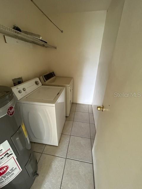 354 Camillia Ln Unit B, Port Charlotte, FL 33954 - laundry room with water heater, washing machine and dryer, and light tile patterned floors