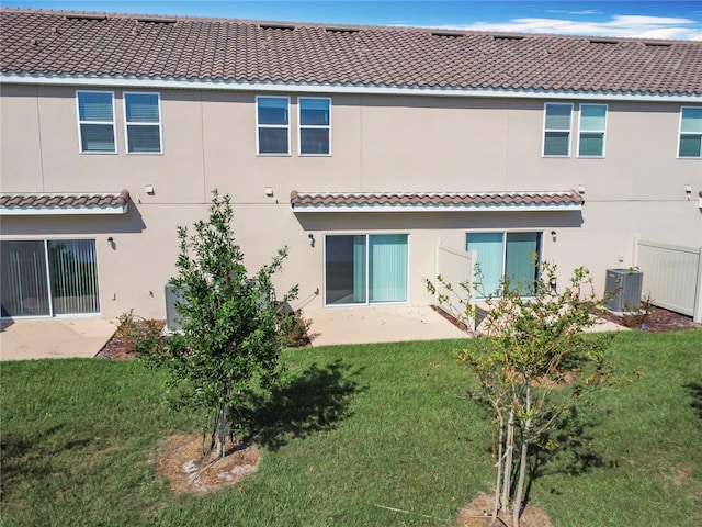 rear view of house with a yard and central AC unit