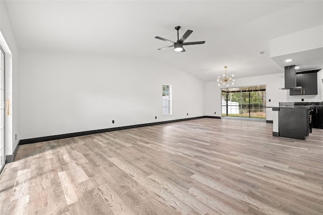 unfurnished living room with vaulted ceiling, light hardwood / wood-style flooring, and ceiling fan with notable chandelier