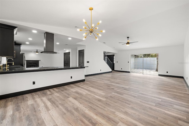 unfurnished living room featuring an inviting chandelier, lofted ceiling, sink, and light hardwood / wood-style floors