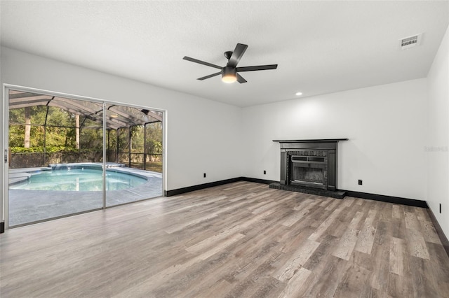 unfurnished living room featuring ceiling fan, a textured ceiling, and light wood-type flooring