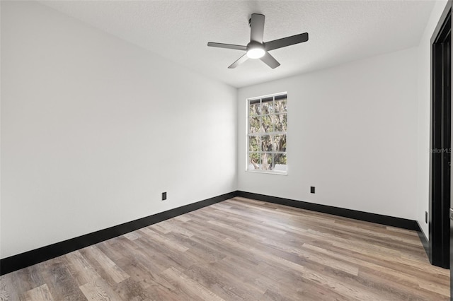 empty room featuring a textured ceiling, light wood-type flooring, and ceiling fan